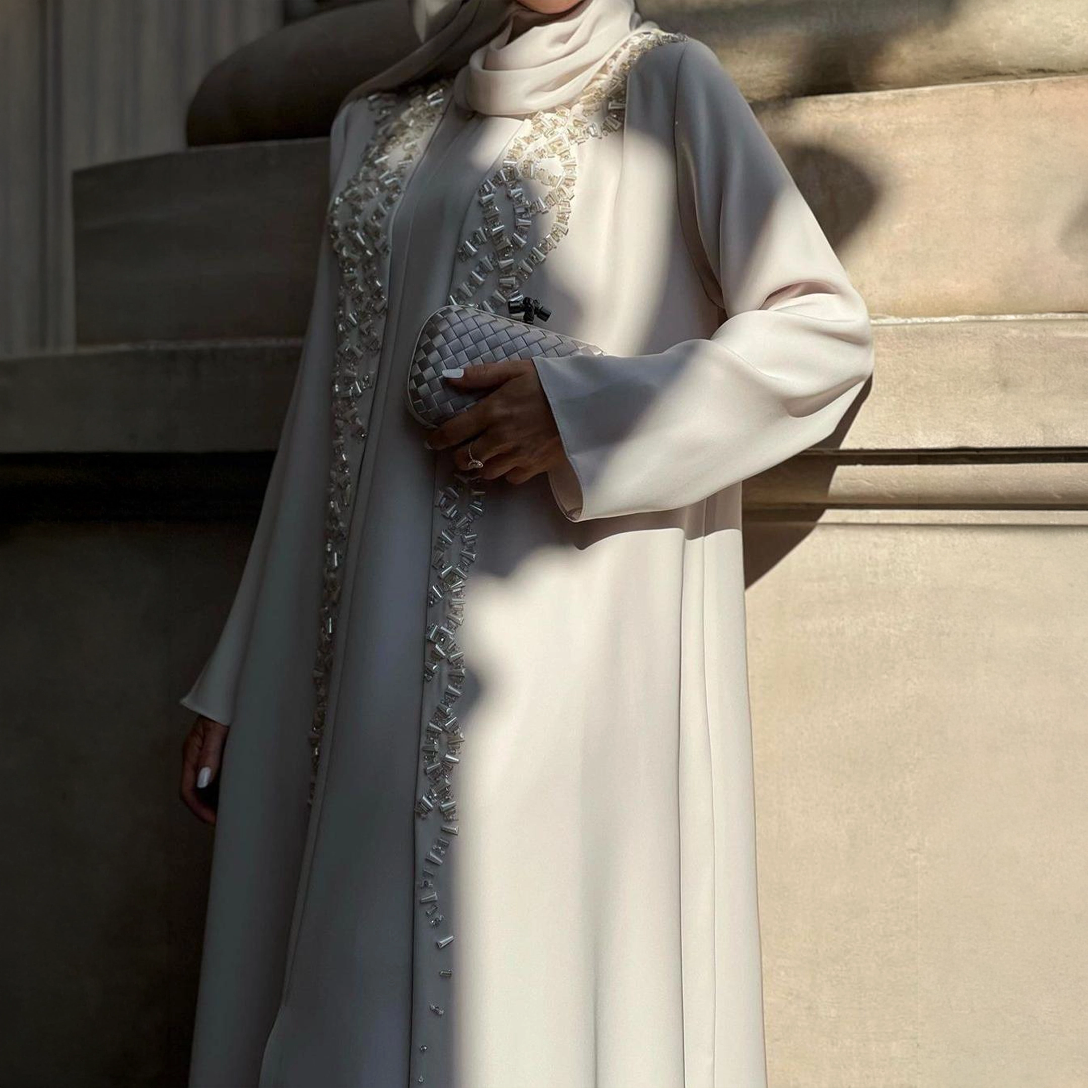 عباية فاخرة بتصميم راقٍ بلون عاجي هادئ، مزينة بتطريزات دقيقة تضيف لمسة فخامة وخفة لكل إطلالة.